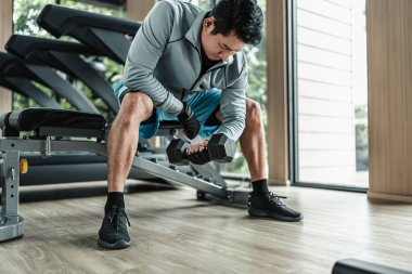 Spor salonunda halterle pazı egzersizi yapan bir adam. Fitness, egzersiz ve trans konsepti.