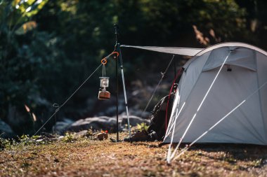 Kamp feneri direkler ve çadırlarda asılı, yamaçlara kurulmuş, şelalelerden akan su akıntılarının yanında..