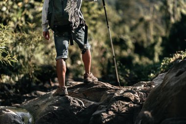 Ormandaki şelaleden akan kayalıklarda yürüyen yürüyüşçüler..