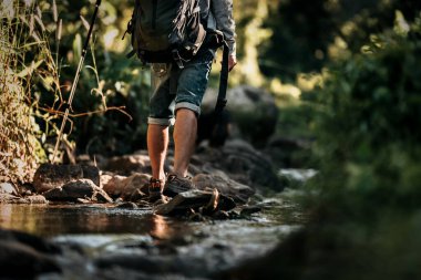 Ormandaki şelaleden akan kayalıklarda yürüyen yürüyüşçüler..