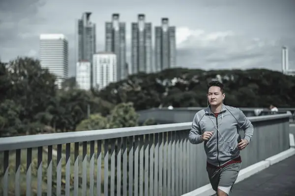 sport man running and listen music earphone and  use smartphone Fitness application, social media, listening to music. Health and Lifestyle in big city life concept.