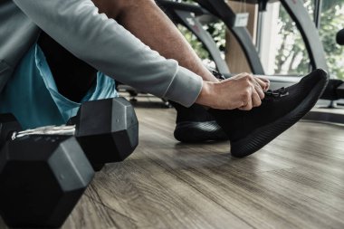 Spor salonunda bağcıklarını bağlayan adamın elleri. Fitness, egzersiz ve konseptte geçiş.