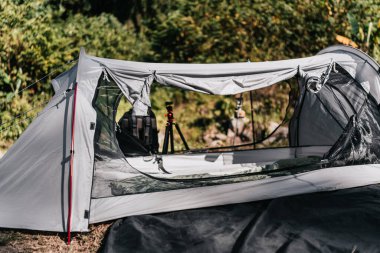  Şelalelerden akan su derelerinin yanındaki yamaçlara çadırlar kurulmuştu. Ocaklı konserve benzin, yürüyüş ayakkabıları, yerde yürüyüş direği..