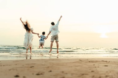 Aile mutluluğundan ellerini kaldırarak atlıyor, tatilde, tatilde, seyahatte, uzun haftasonunda, yazda ya da başka bir tatilde ailesiyle sahilde eğleniyor. Birlikte vakit geçirmekten mutlular..