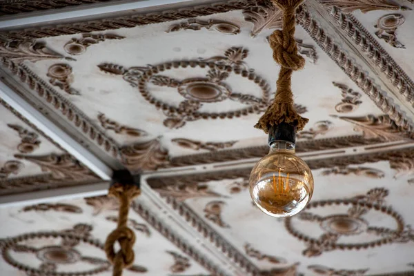 stock image The vintage light bulb hanging on the ceiling of an old building. A Retro Edison light bulb hanging on the ceiling