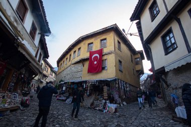 Türkiye 'nin Cumalikizik köyündeki eski evler. Eski kasabadaki geleneksel evler. Ev duvarında Türk bayrağı.