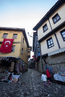 Türkiye 'nin Cumalikizik köyündeki eski evler. Eski kasabadaki geleneksel evler. Ev duvarında Türk bayrağı.