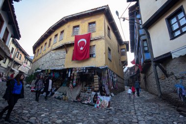 Türkiye 'nin Cumalikizik köyündeki eski evler. Eski kasabadaki geleneksel evler. Ev duvarında Türk bayrağı.