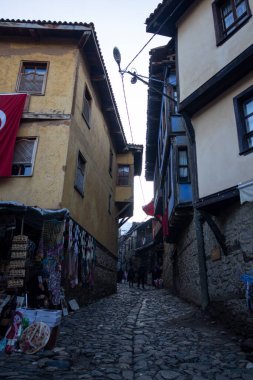 Türkiye 'nin Cumalikizik köyündeki eski evler. Eski kasabadaki geleneksel evler. Ev duvarında Türk bayrağı.