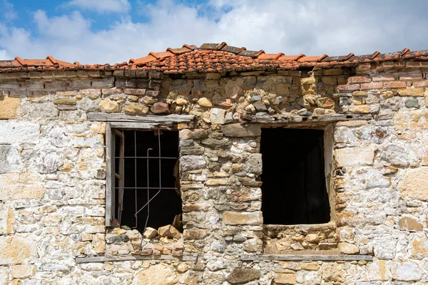 Önünde kırık bir pencere olan eski bir taş evin penceresi, köydeki eski bir evin kalıntıları.. 