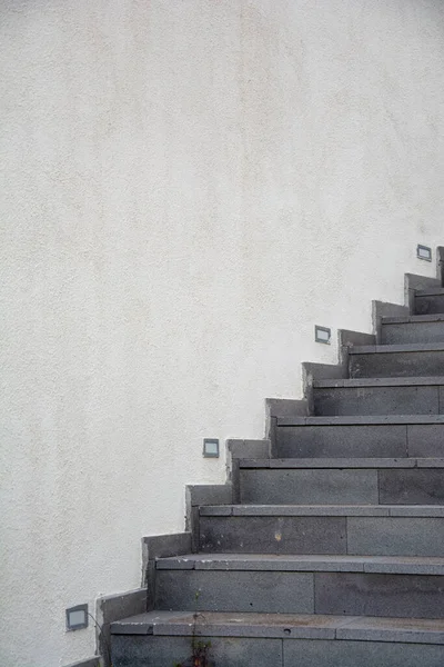 公園内の建物の白い壁の階段 白いセメントの壁の背景の灰色の石の階段 — ストック写真