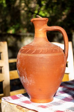Bahçedeki bir masada kil sürahi, fotoğrafa yakın çekim. Klasik stil.