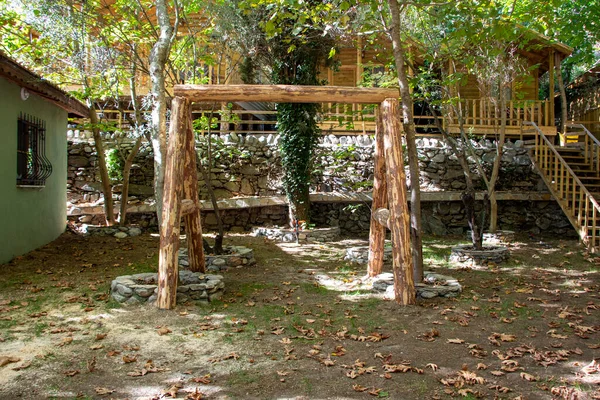 村子里一座房子的花园里有一个木制的乔木 村里一幢房子花园里的木制秋千 — 图库照片