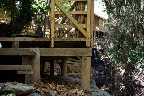 stock image Wooden bridge over the river in the forest with dry leaves. Wooden pathway over the river in the forest.