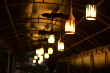 Parkın tavanında asılı duran klasik ampuller. Geceleri bir kafede tavandan sarkan lambalar..