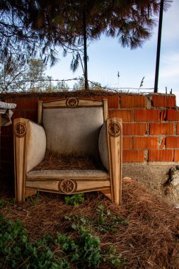 Bahçedeki doğal malzemeden yapılmış ahşap mobilyalar. Sahildeki terk edilmiş eski koltuk tuğla duvarın yanında. Plajdaki eski mobilyalar.. 