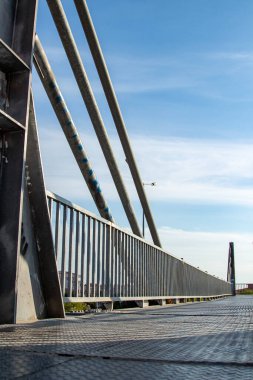 Modern bir köprünün çelik yapısının yakın görüntüsü. Caddedeki metal çitlere yakın çekim. Arka planda mavi gökyüzü olan çelik bir köprünün ayrıntıları.