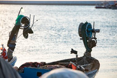 Gün batımında denizde balıkçı teknesi. Bir balıkçı teknesinde bobin. Sığ alan derinliği.