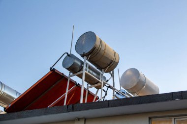 Evin çatısındaki güneş suyu ısıtma sistemi mavi gökyüzüne karşı. Su ısıtma sistemi için güneş enerjisi.