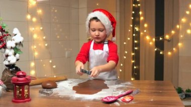 Sevimli çocuk evde Noel kurabiyesi pişiriyor, eğleniyor. Yüksek kalite 4k görüntü