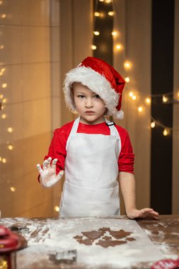Noel Baba 'nın kırmızı gömleği ve beyaz önlüğüyle Noel arifesinde Noel kurabiyesi yaparken mutluyuz. Yüksek kalite fotoğraf