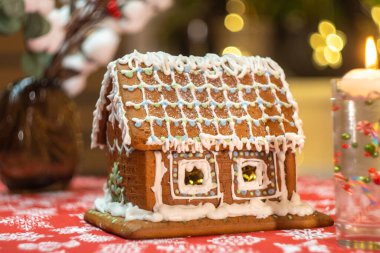 Masa örtüsü, süslemeleri, mumları ve fenerleri olan küçük zencefilli kurabiye evi. Işıklı oturma odası. Tatil havası. Yüksek kalite fotoğraf