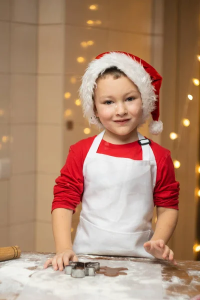Kid cutting out shapes and making cookies. Making biscuits for Christmas decorations. Childrens art project, a craft for children. High quality photo