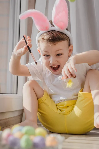 Мальчик Носит Кроличьи Уши Рисует Пасхальные Яйца Пасхальной Охоте Яйцами — стоковое фото