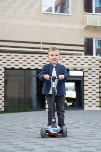 Küçük mutlu çocuk scooter 'a biniyor. Yüksek kalite fotoğraf