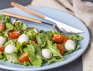 Mozarella topları, domates, roka ve balzamik soslu Caprese salatası. Lezzetli, sağlıklı İtalyan yemeği konsepti..