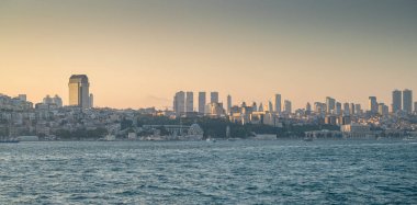 Gün batımında denizden İstanbul 'a manzara. Şehrin çevresinde eski ve yeni evleri olan kıyı şeridi. Yaz panoramik manzarası. Türkiye.