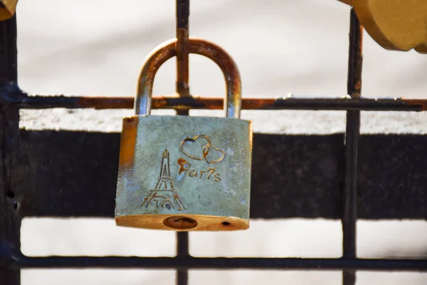Wedding key lock with a heart and Paris on the bridge close-up on a sunny summer day. Paris, France.