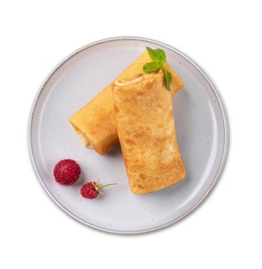 Beyaz arka planda, ahududu ve nane aromalı ev yapımı krep. Sağlıklı gıda konsepti. Üst görünüm.