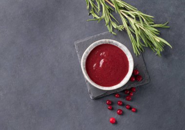 Koyu arkaplanda taze böğürtlen ve biberiye bulunan bir kasede el yapımı sulu orman reçeli. Ev yapımı sağlıklı yemekleri hesaba katın. Üst görünüm ve kopyalama alanı.