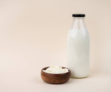 Şişede çiftlik sütü ve süzme peynir. Sağlıklı ve besleyici beslenme kavramı. Mayalanmış ürün. Boşluğu kopyala.