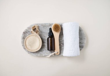 Yüz ve vücut bakımı kozmetik ürünleri krem, fırça, sünger ve havluyla mermer zemine serilmiş. Sıfır atık. Üst görünüm ve kopyalama alanı.
