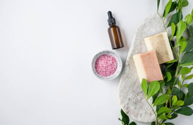 Beyaz zemin üzerinde pembe deniz tuzu, sabun ve krema ve brunch ile yüz ve vücut bakım kozmetik düz konsept. Üst görünüm ve kopyalama alanı.