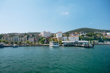 Dağlarda evleri ve Türkiye 'nin Adalar kentinde tekneleri olan bir iskelesi olan tatil köyünün panoramik deniz manzarası.