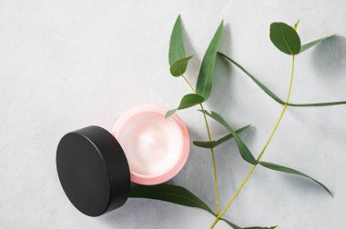 Arka planda yüz ve vücut kremi var. Yakın plan. Ökliptüslü kozmetik bakım konsepti. Sağlık ve güzellik. Üst görünüm ve kopyalama alanı.