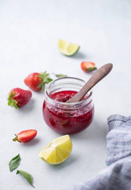 Çilek reçeli kavanozda, arka planda taze böğürtlenlerle. Ev yapımı lezzetli ve sağlıklı konserve yiyecekler. Metin için boş alan.