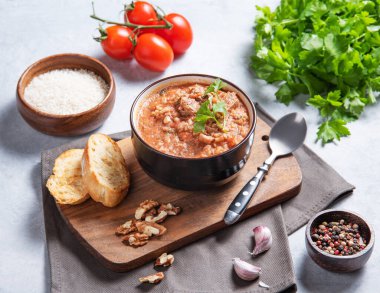 Pirinç, domates, ceviz ve baharatlı kharço çorbası ve taze domates, otlar ve ekmekle hafif bir arka planda. Geleneksel bir Kafkas halk yemeği..