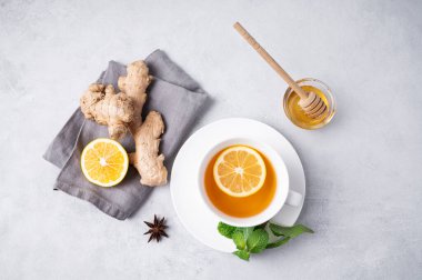 Limonlu, ballı, naneli ve zencefilli bir fincan çay. Dokunulmazlık için sağlıklı içecek konsepti. Metin için üst görünüm ve boşluk.
