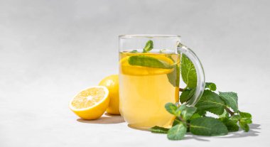 Aroma, arka planda nane aromalı bir bardak limon çayı. Bağışıklık ve güç için sağlıklı bir kahvaltı içeceği konsepti. Metin için ön görünüm ve boş alan.