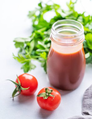 Acılı sos. Biber ve domatesli ev yapımı aperatif hafif arka planda bir şişe taze bitki ve sebzelerle yakın plan. Kafkas ve Gürcistan yemekleri kavramı.