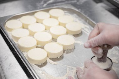 Bir kadın el yapımı cheesecake yapıyor. Yiyecek üretimi için fabrika. El yapımı iş.