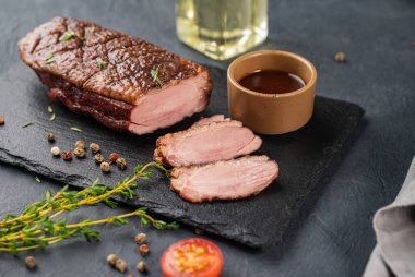 Salamura soslu ızgara barbekü ördeği göğsü ve koyu arkaplanda taze otlarla birlikte sos. Sağlıklı diyet yemekleri.