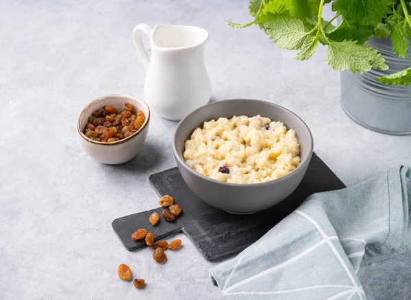 stock image Corn porridge with rasin in a bowl on a blue background with milk. The concept of a delicious, nutritious and healthy breakfast. Traditional Italian food.