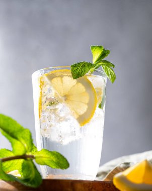 Taze limonlu limonata, naneli ve buzlu olsun. Hafif arka planda limonlu mojito kokteyli tazeleniyor. Yaz soğuk içecekler konsepti. Ön görünüm ve boşluk kopyala.