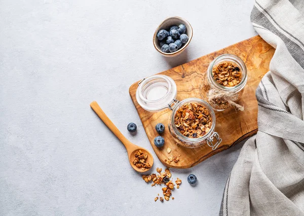 stock image Homemade baked granola with nuts and fresh blueberry in a jar on a light background. Healthy vegetarian muesli for breakfast. Top view and free space for text.