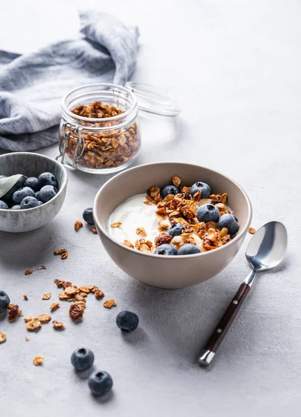 Stock image The concept of a healthy breakfast of yogurt, granola and fresh blueberry on a light background. Homemade diet and protein food. Copy space.